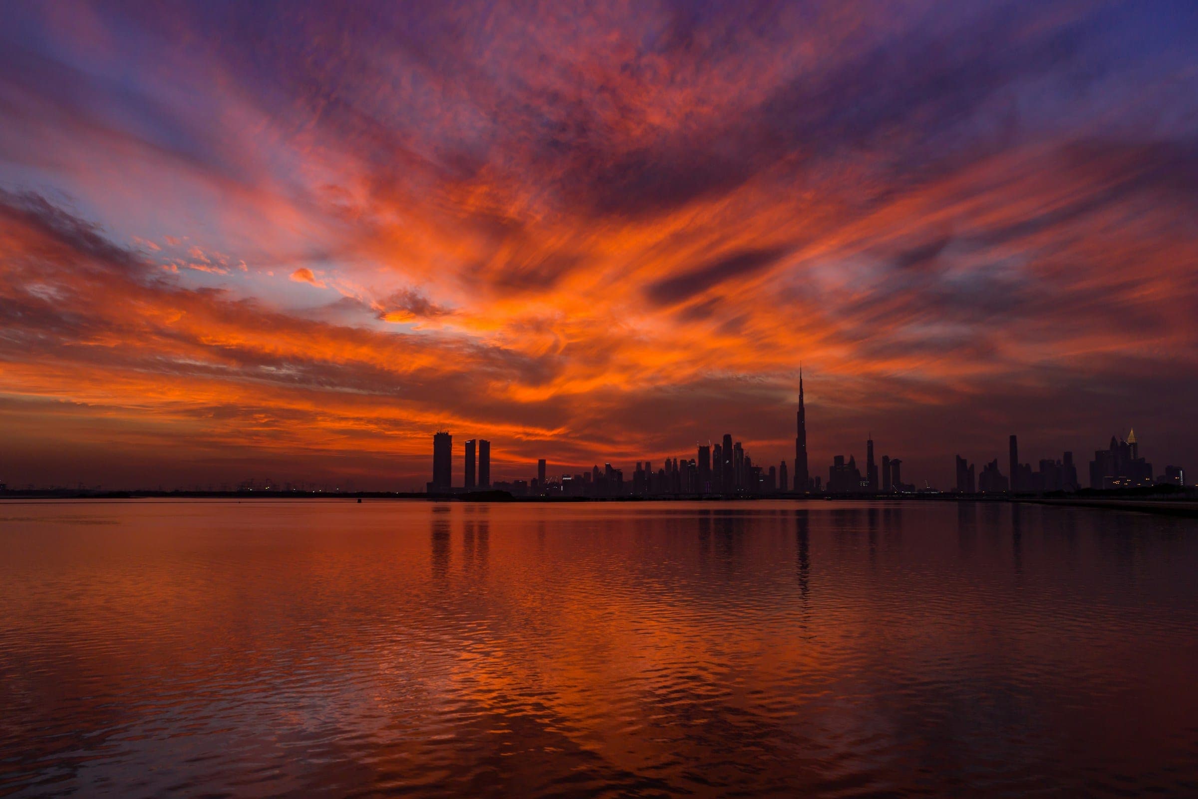The Dubai skyline across the water at sunset